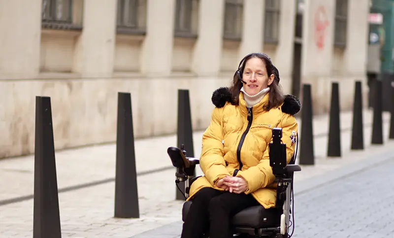 A woman using a Switch-It Vigo to control her power wheelchair