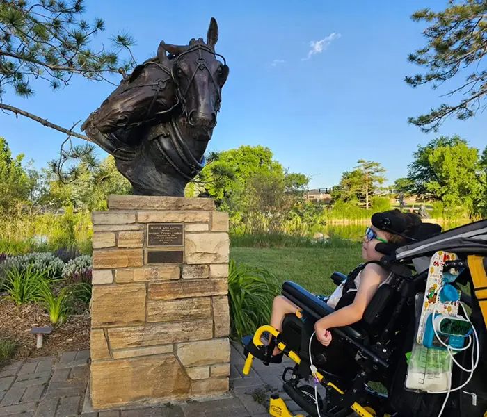 Gabriel looking at a horse statue