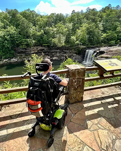 A man using power seat elevate on his wheelchair