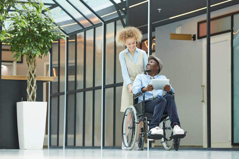 A man using a wheelchair with his caregiver