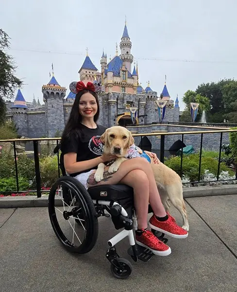 Aspen with her service dog at Disneyland